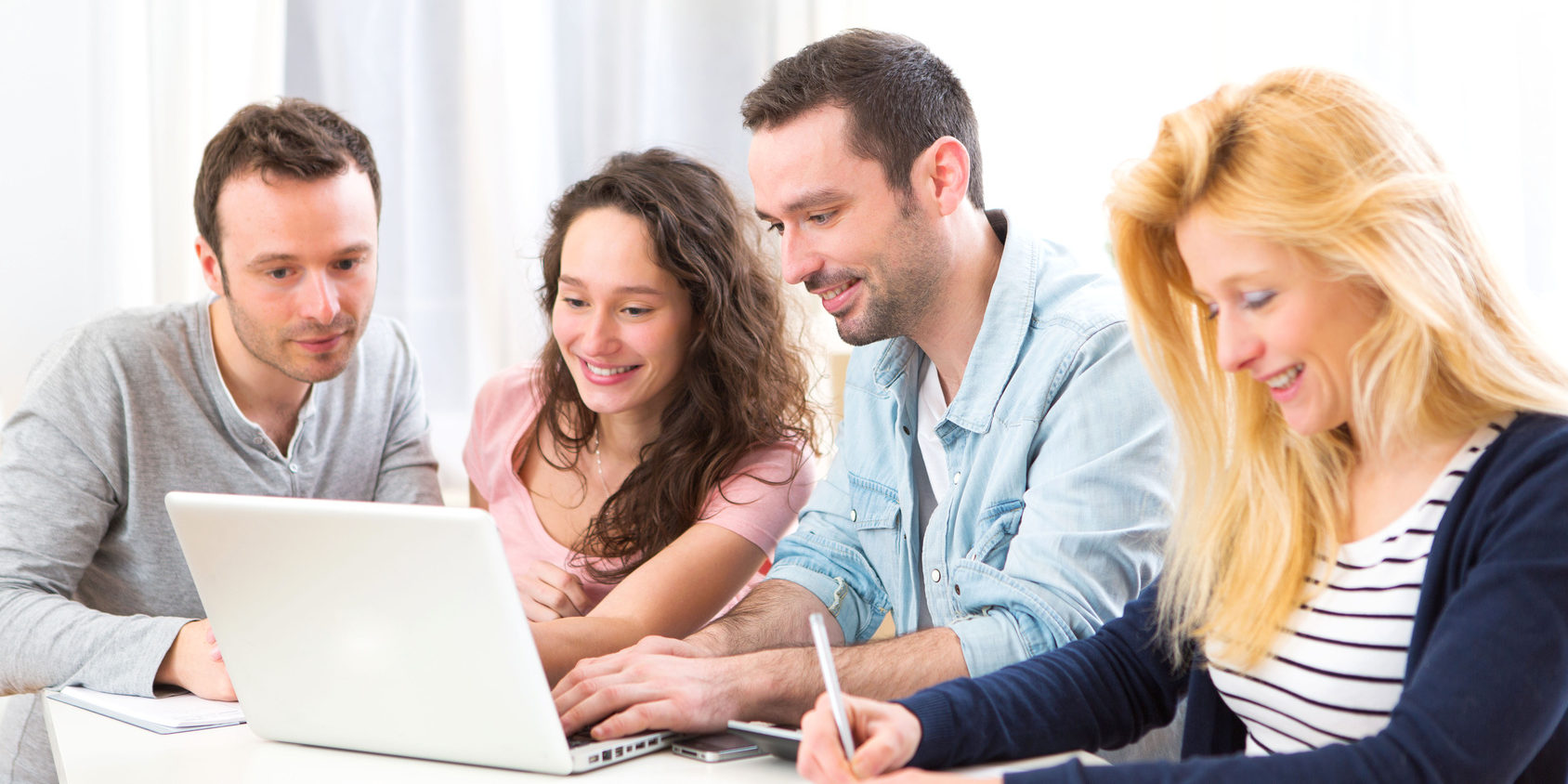 Group of 4 young attractive people working on a laptop