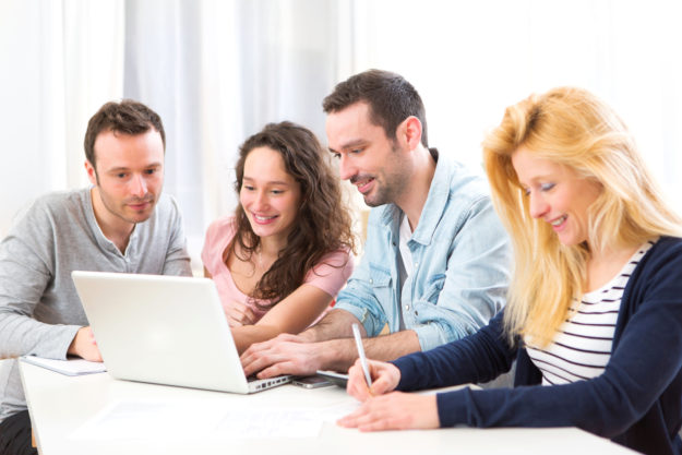 Group of 4 young attractive people working on a laptop