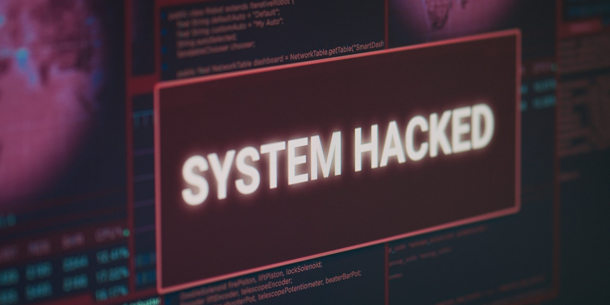 Computer monitor showing hacked system alert message flashing on screen